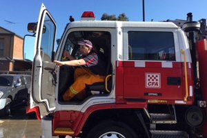 Able client Robert sitting inside a red and white CFA fire truck.