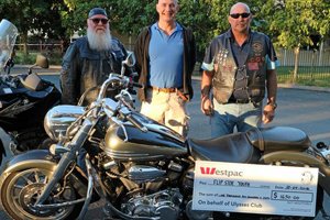 'Fathers' and 'Waffles' of the Ullysses Bike club standing with Edmund McMahon of Able Australia with a large cheque for $1650