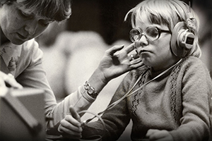 Black and White photo of young boy with glasses and headphones