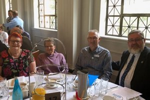 Able volunteer Daryl sitting at a table with three others at the Volunteer of the Year awards