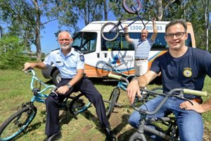 Three men on bikes in front of an Able Australia bus