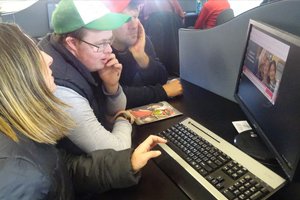 tasTAFE students sitting with Able clients using a computer at the TAFE.