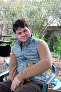 A photo of Gianni smiling as he holds a lizard