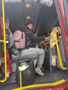 A photo of Rebecca smiling in the fire truck